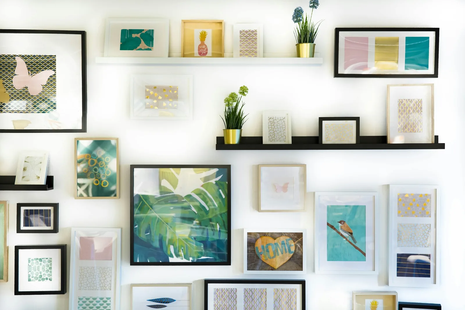 A dense gallery wall of framed prints and photographs, evenly spaced.