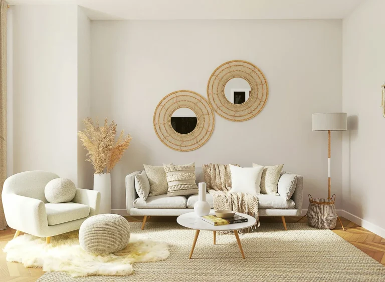 A styled living room with round mirrors above a pale sofa, dried stems and a soft rug.