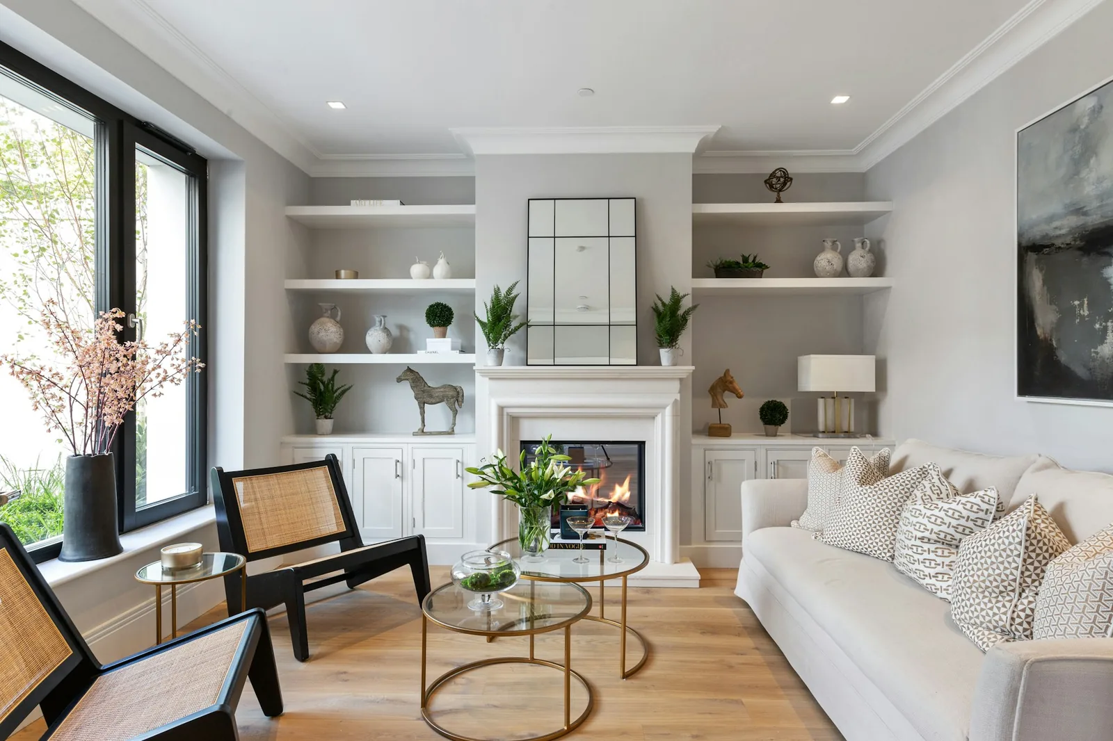 A bright living room after a refresh: pale walls, framed prints and a wall-mounted television above a low console.
