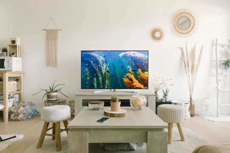 A wall-mounted television above a low console, cables concealed.