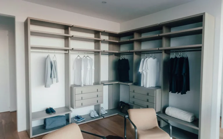 A fitted walk-in wardrobe with hanging rails, open shelving and drawers.
