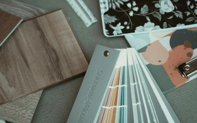 Flooring and wallpaper sample decks fanned out on a table.