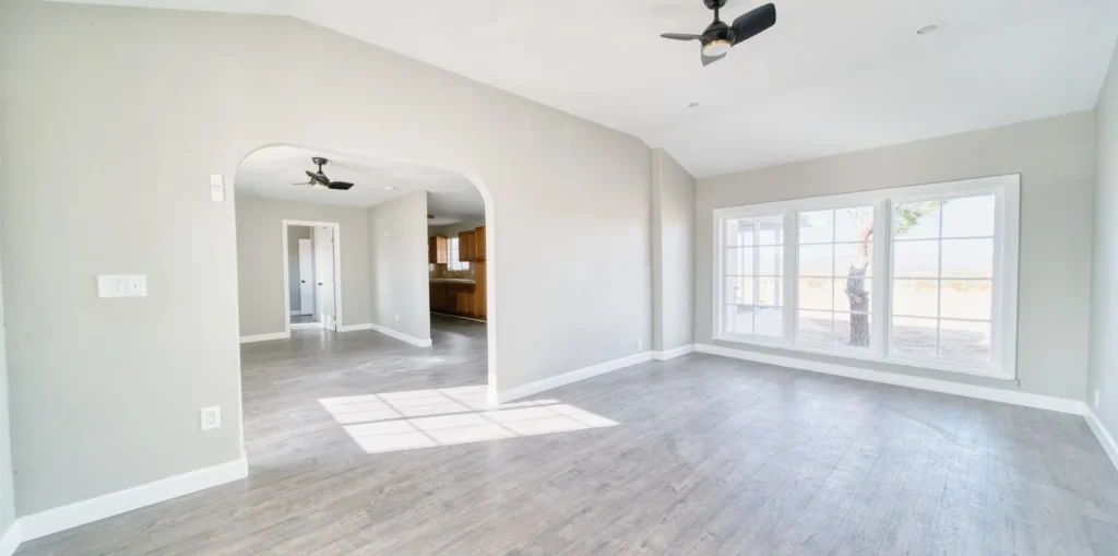 An open-plan dining area empty before styling, with bare floor and no furniture.