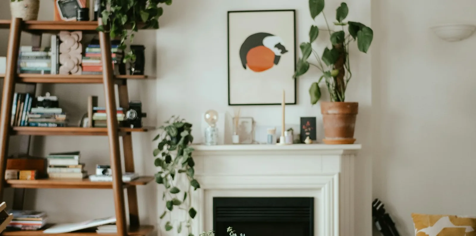 The same lived-in living room after styling: surfaces cleared, shelving edited and the seating re-set around the fireplace.