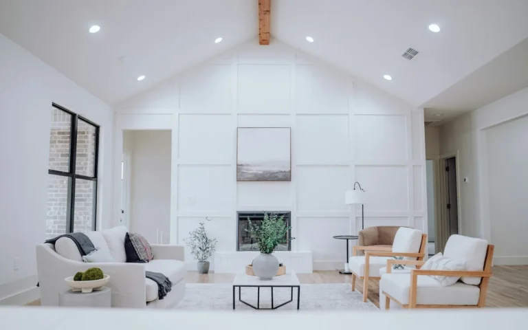An empty open-plan living room furnished with a few pale pieces for a listing.